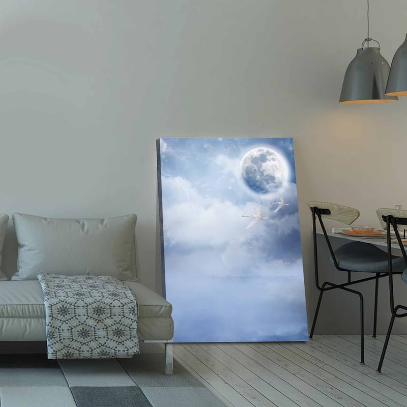 Canvastavla 70x100 cm - Två svanar som flyger under en stor måne i en drömlik, molnig himmel - Ljusblå / Vit / Mörkblå - Inredning - Tavlor & posters - Canvastavla