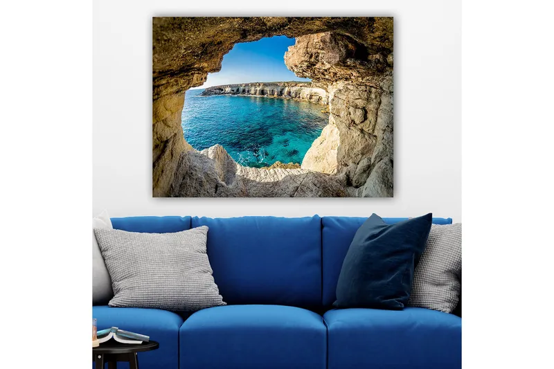 Canvastavla 70x100 cm - Utsikt genom en klippöppning mot en klarblå havsstrand - Blå / Beige / Vit - Inredning - Tavlor & posters - Canvastavla