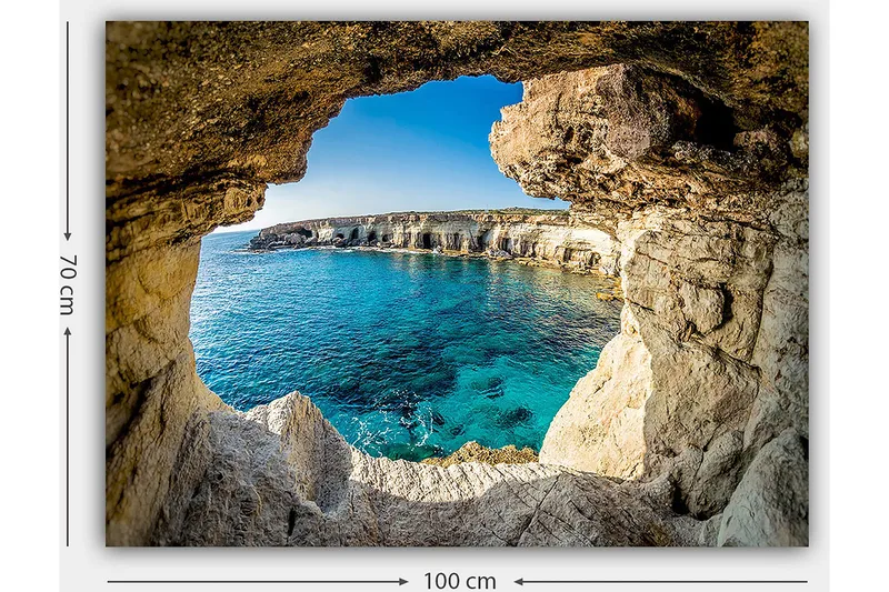 Canvastavla 70x100 cm - Utsikt genom en klippöppning mot en klarblå havsstrand - Blå / Beige / Vit - Inredning - Tavlor & posters - Canvastavla