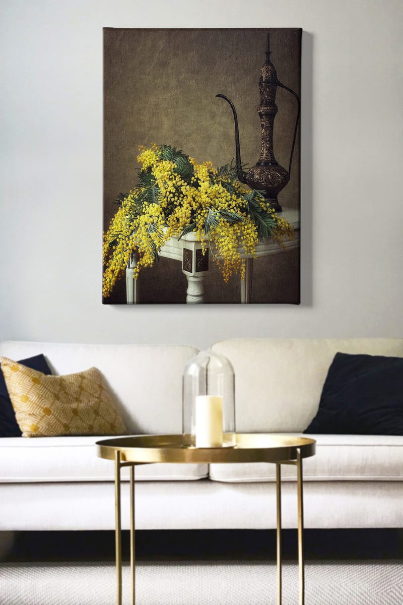 Canvastavla 70x100 cm - Vacker bukett av mimosa blommor i gult, placerad på ett bord bredvid en elegant, mörkbrun kanna - Gult / Mörkgrönt / Brunt - Inredning - Tavlor & posters - Canvastavla