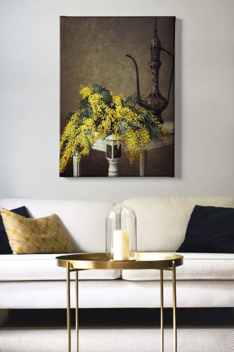 Canvastavla 70x100 cm - Vacker bukett av mimosa blommor i gult, placerad på ett bord bredvid en elegant, mörkbrun kanna - Gult / Mörkgrönt / Brunt - Inredning - Tavlor & posters - Canvastavla