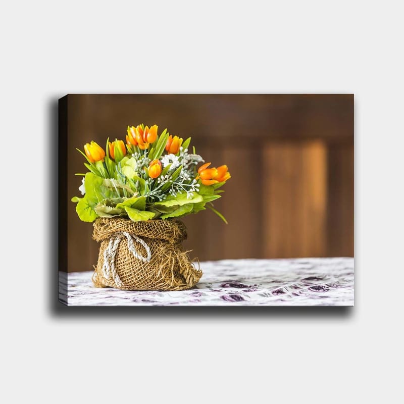 Canvastavla 70x100 cm - Vacker bukett med orange tulpaner och gröna blad i en jutevävskorg, Orange / Grön / Vit