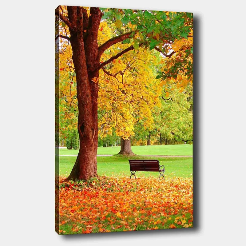 Canvastavla 70x100 cm - Vacker höstscen med en bänk under ett färgsprakande träd, Guldgul / Orange / Brun