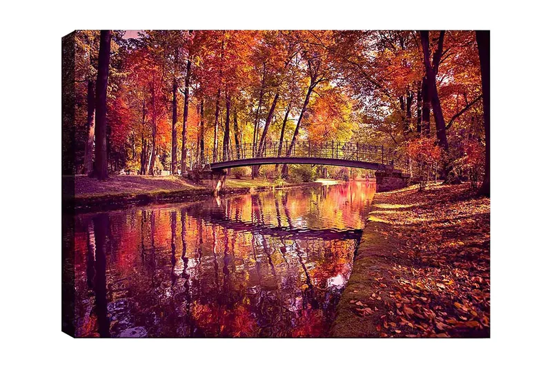 Canvastavla 70x100 cm - Vacker höstscen med en bro som sträcker sig över en spegelblanka vattenyta omgiven av färgglada träd, Orange / Röd / Gul