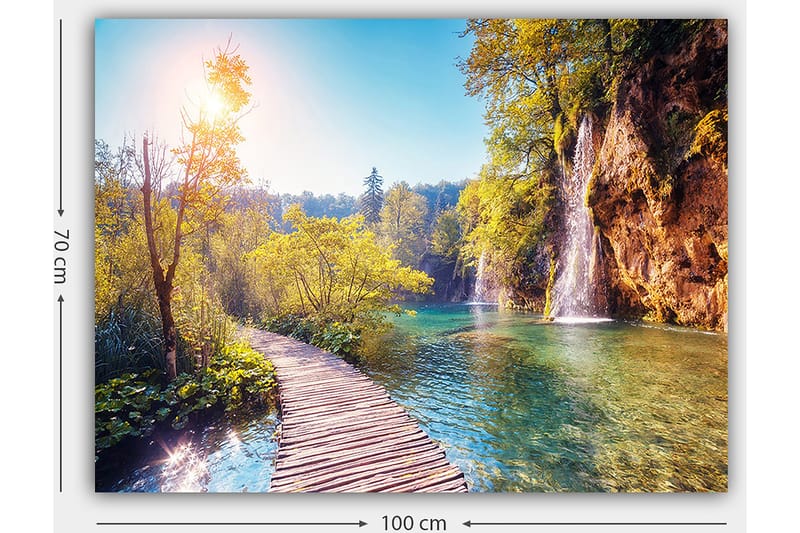 Canvastavla 70x100 cm - Vacker naturvy med en träbro som leder genom grönskande landskap och en vattenfall i bakgrunden - Grön / Blå / Gul - Inredning - Tavlor & posters - Canvastavla