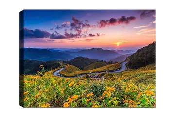 Canvastavla 70x100 cm - Vacker solnedgång över en blomstrande dal med slingrande vägar och berg i bakgrunden - Gult / Grönt / Blått - Inredning - Tavlor & posters - Canvastavla