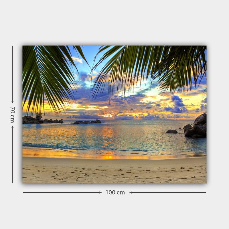 Canvastavla 70x100 cm - Vacker solnedgång över en strand med palmer som ramar in motivet - Blå / Orange / Grön - Inredning - Tavlor & posters - Canvastavla
