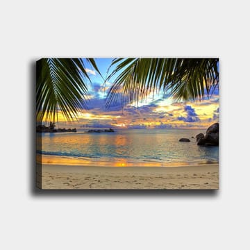 Canvastavla 70x100 cm - Vacker solnedgång över en strand med palmer som ramar in motivet - Blå / Orange / Grön - Inredning - Tavlor & posters - Canvastavla
