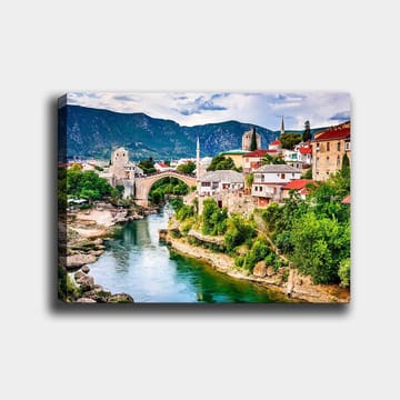 Canvastavla 70x100 cm - Vacker vy över en historisk bro som sträcker sig över en flod, omgiven av pittoreska hus och grönskande landskap - Grön / Blå / Röd - Inredning - Tavlor & posters - Canvastavla