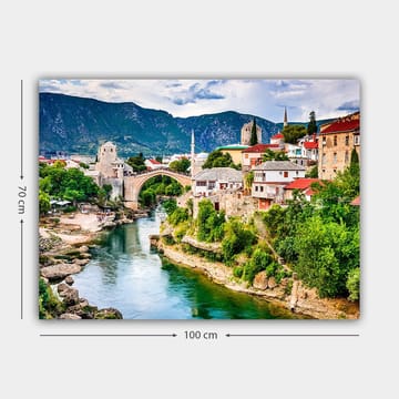 Canvastavla 70x100 cm - Vacker vy över en historisk bro som sträcker sig över en flod, omgiven av pittoreska hus och grönskande landskap - Grön / Blå / Röd - Inredning - Tavlor & posters - Canvastavla