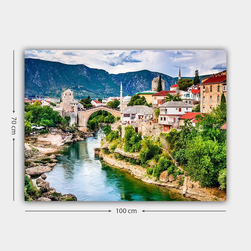 Canvastavla 70x100 cm - Vacker vy över en historisk bro som sträcker sig över en flod, omgiven av pittoreska hus och grönskande landskap - Grön / Blå / Röd - Inredning - Tavlor & posters - Canvastavla