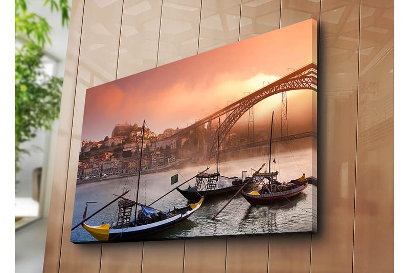 Canvastavla 70x100 cm - Vacker vy av floden med traditionella båtar och en majestätisk bro i bakgrunden, omgiven av färgglada hus - Orange / Blå / Gul - Inredning - Tavlor & posters - Canvastavla