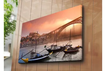 Canvastavla 70x100 cm - Vacker vy av floden med traditionella båtar och en majestätisk bro i bakgrunden, omgiven av färgglada hus - Orange / Blå / Gul - Inredning - Tavlor & posters - Canvastavla