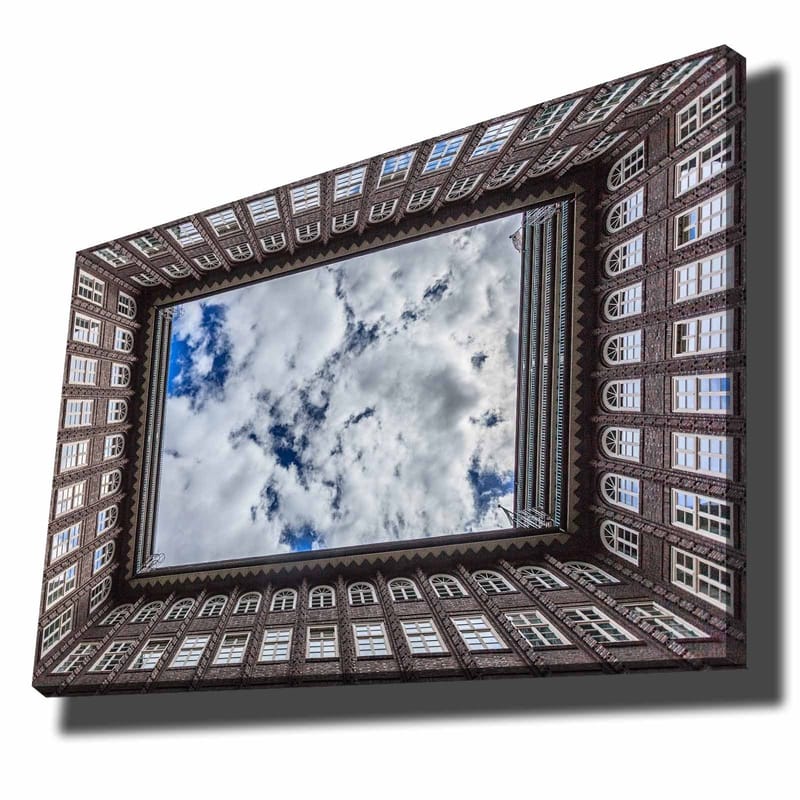 Canvastavla 70x100 cm - Vy av en byggnadsfasad som ramar in en spegelbild av himlen, Mörkbrun / Vit / Ljusblå