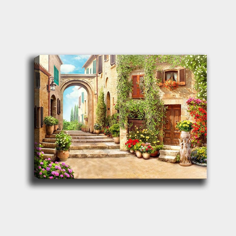 Canvastavla 70x100 cm - Pittoresk gata med blommor och grönska i en charmig bymiljö, Grön / Gul / Rosa