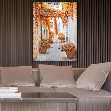 Canvastavla 70x100 cm - Pittoresk gränd omgiven av färgglada höstlöv och krukväxter - Orange / Brunt / Gult - Inredning - Tavlor & posters - Canvastavla