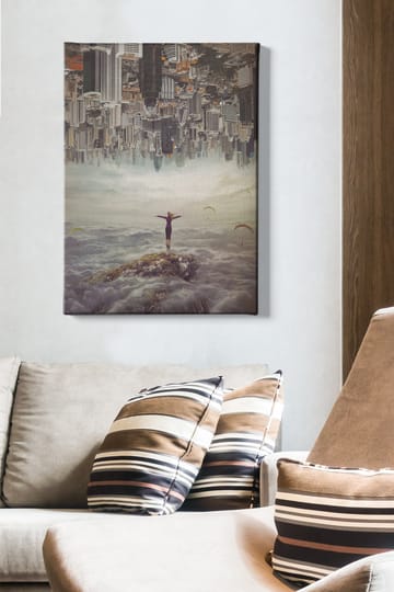 Canvastavla 70x100 cm - Person står med utsträckta armar på en klippa ovanför molnen, med en stad i bakgrunden som är upp och ner - Grå / Beige / Mörkblå - Inredning - Tavlor & posters - Canvastavla