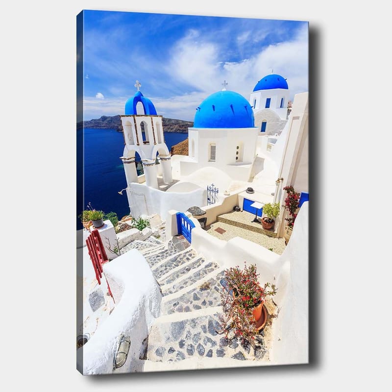 Canvastavla 70x100 cm - Pittoresk vy av vita hus med blå kupoler och en stenlagd väg i en grekisk ö-miljö, Blå / Vit