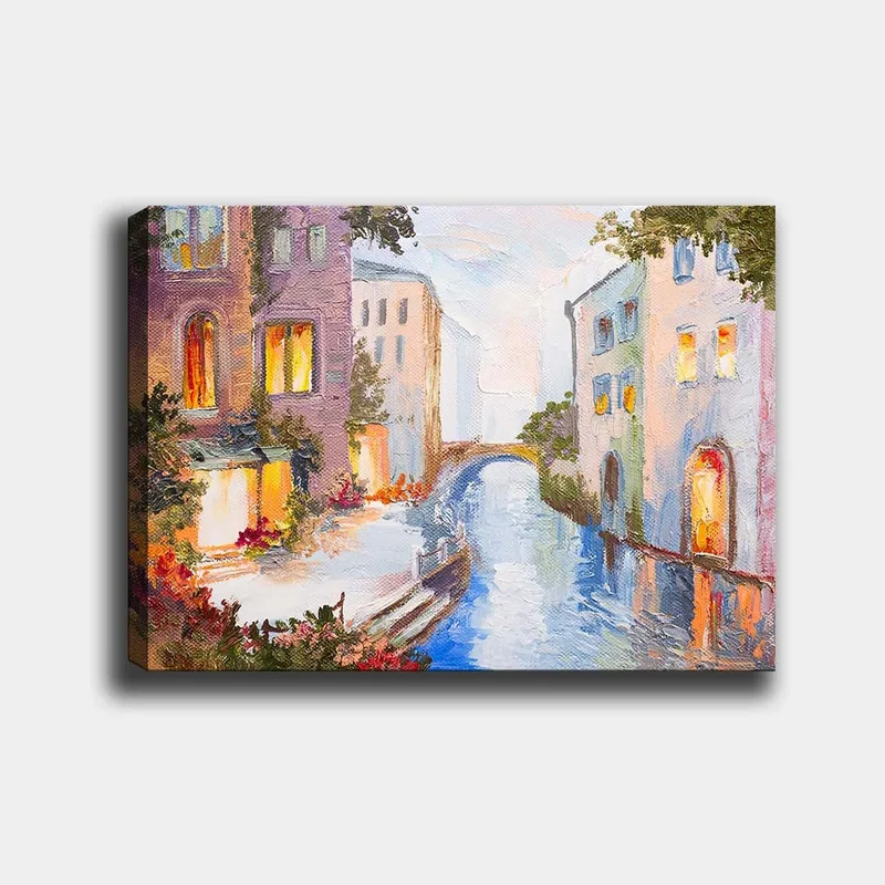 Canvastavla 70x100 cm - Pittoresk kanal med färgglada hus och en bro som speglas i vattnet, Ljusblå / Lila / Orange