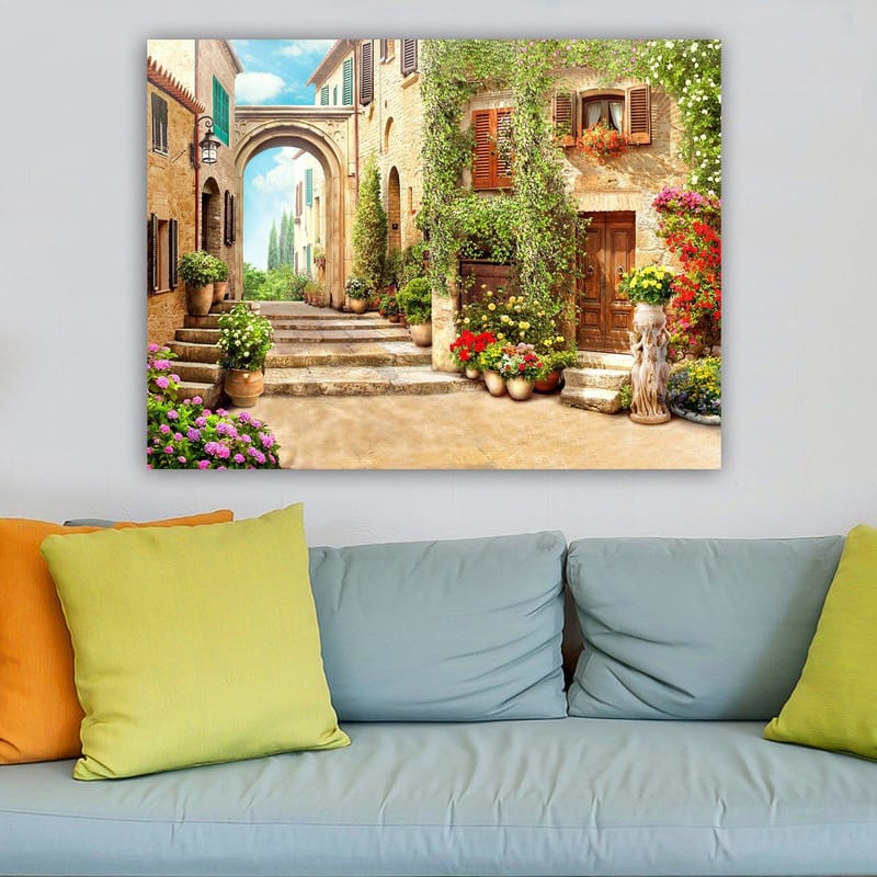 Canvastavla 70x100 cm - Pittoresk gata med blommor och grönska i en charmig bymiljö - Grön / Gul / Rosa - Inredning - Tavlor & posters - Canvastavla