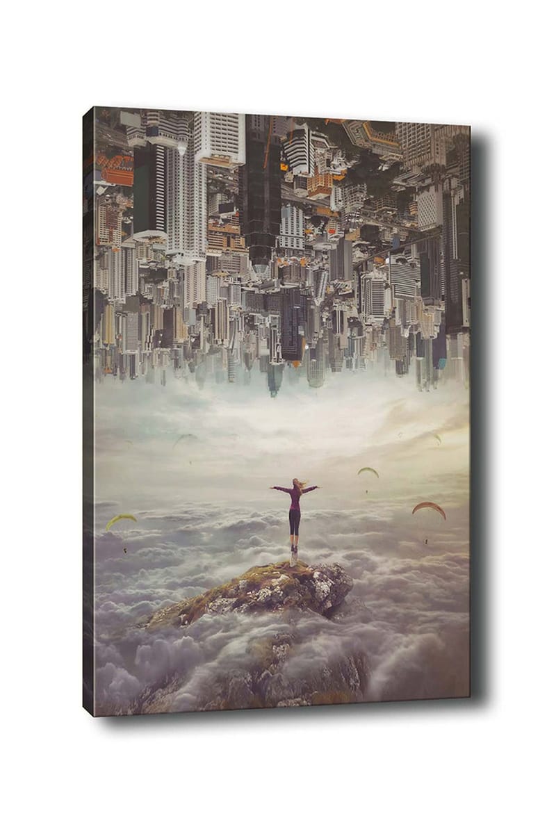 Canvastavla 70x100 cm - Person står med utsträckta armar på en klippa ovanför molnen, med en stad i bakgrunden som är upp och ner, Grå / Beige / Mörkblå