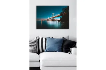 Canvastavla - Ljusbelyst bro över en stilla vattenyta med stadssilhuett i bakgrunden - Blå / Orange / Svart - Inredning - Tavlor & posters - Canvastavla