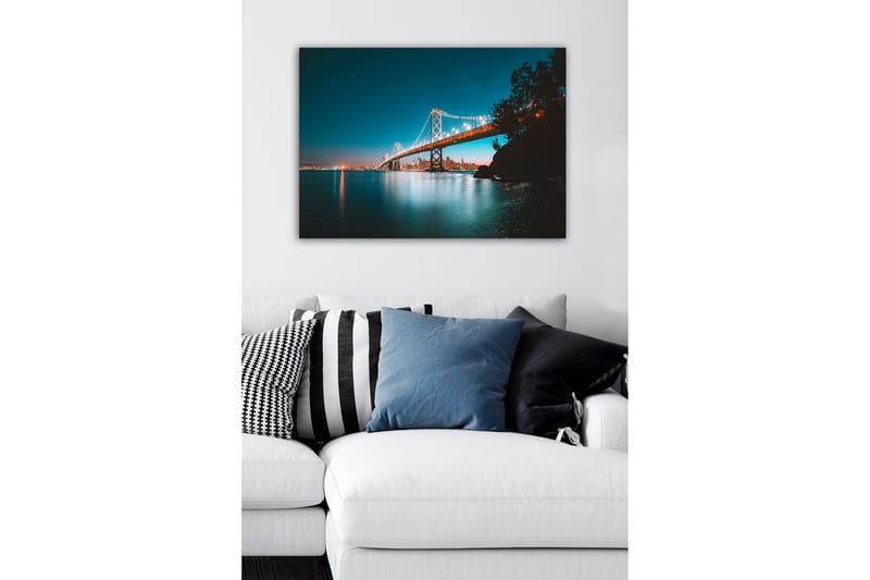 Canvastavla - Ljusbelyst bro över en stilla vattenyta med stadssilhuett i bakgrunden - Blå / Orange / Svart - Inredning - Tavlor & posters - Canvastavla