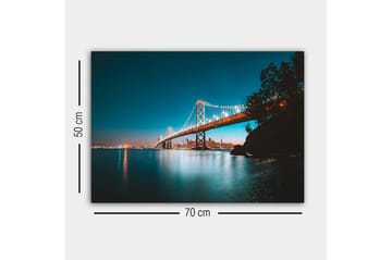 Canvastavla - Ljusbelyst bro över en stilla vattenyta med stadssilhuett i bakgrunden - Blå / Orange / Svart - Inredning - Tavlor & posters - Canvastavla