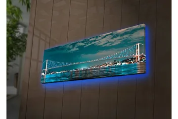 Canvastavla med LED-belysning 30x90 cm - Bro över en stilla vattenyta med stadsljus i bakgrunden - Mörkblå / Turkos / Ljusgrön - Inredning - Tavlor & posters - Canvastavla