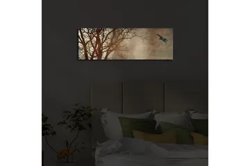 Canvastavla med LED-belysning 30x90 cm - Silhuett av träd med en fågel i flykt mot en mjukt tonad bakgrund - Mörkbrun / Beige / Svart - Inredning - Tavlor & posters - Canvastavla