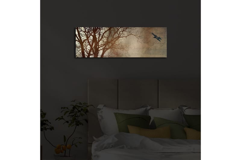 Canvastavla med LED-belysning 30x90 cm - Silhuett av träd med en fågel i flykt mot en mjukt tonad bakgrund - Mörkbrun / Beige / Svart - Inredning - Tavlor & posters - Canvastavla