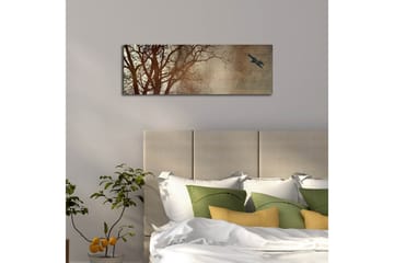 Canvastavla med LED-belysning 30x90 cm - Silhuett av träd med en fågel i flykt mot en mjukt tonad bakgrund - Mörkbrun / Beige / Svart - Inredning - Tavlor & posters - Canvastavla