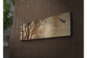 Canvastavla med LED-belysning 30x90 cm - Silhuett av träd med en fågel i flykt mot en mjukt tonad bakgrund - Mörkbrun / Beige / Svart - Inredning - Tavlor & posters - Canvastavla