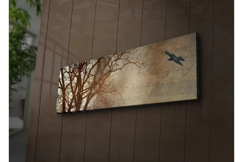 Canvastavla med LED-belysning 30x90 cm - Silhuett av träd med en fågel i flykt mot en mjukt tonad bakgrund - Mörkbrun / Beige / Svart - Inredning - Tavlor & posters - Canvastavla