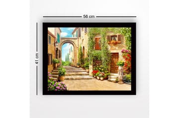 Inramad Canvastavla i trä - 41x56 cm - Charmig gränd med blomsterprydda hus och en båge i bakgrunden - Grön / Gul / Rosa - Inredning - Tavlor & posters - Canvastavla