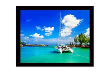 Inramad Canvastavla i trä - 41x56 cm - Segelbåt i en klar, turkos lagun under en blå himmel med vita moln - Turkos / Blå / Vit - Inredning - Tavlor & posters - Canvastavla